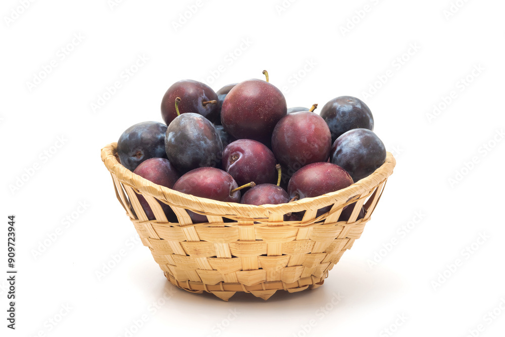 Basket of fresh plums isolated on white background, close-up Basket of fresh plums isolated on white background, close-up