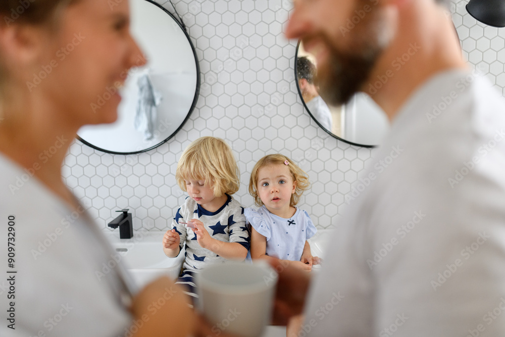 Fototapeta premium Parents and kids having morning bathroom routine, brushing teeth and washing face, enjoying together time.