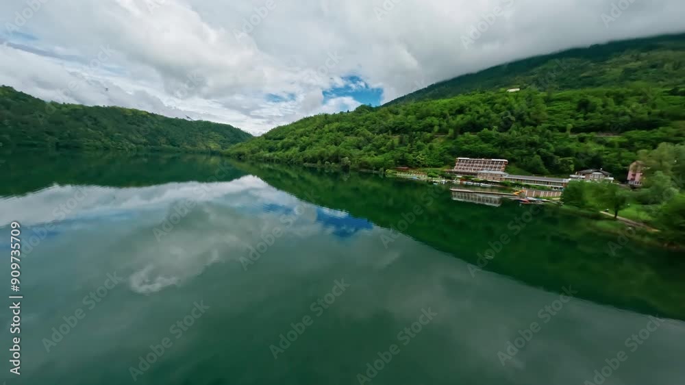 Lago di levico with lush green hills and calm waters on a cloudy day, aerial view Lago di levico with lush green hills and calm waters on a cloudy day, aerial view