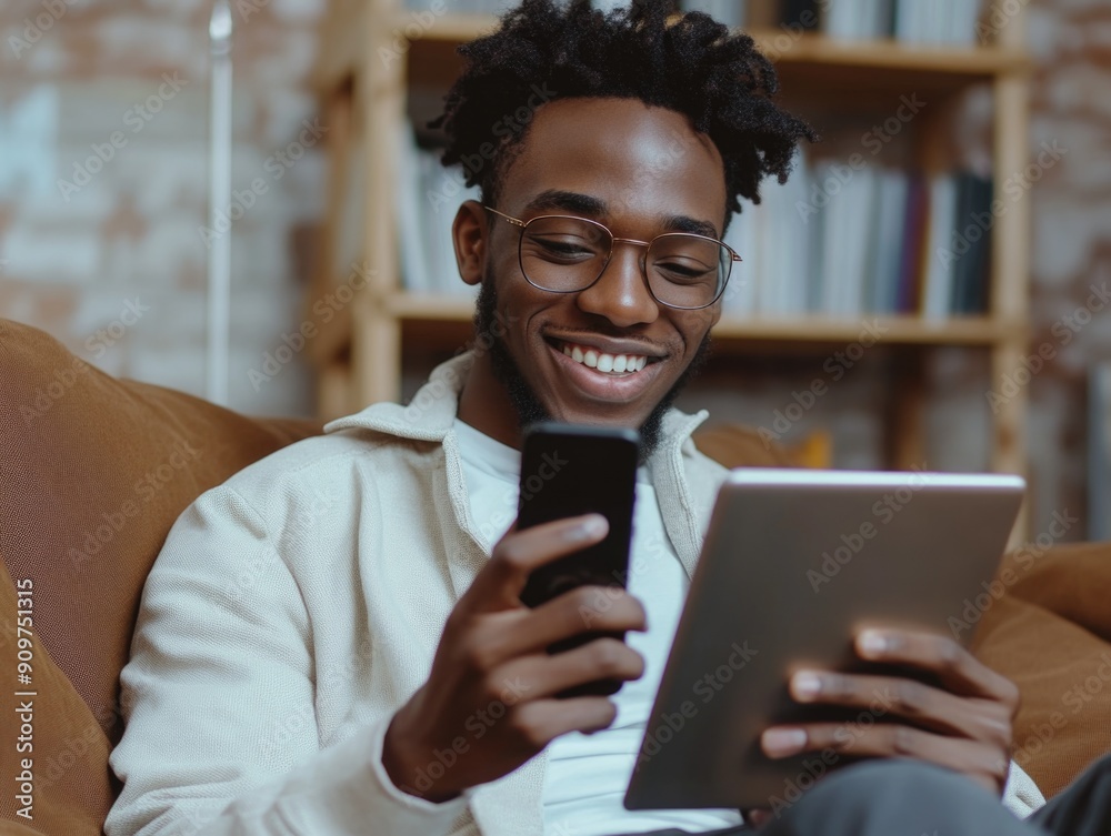 Man sits on a couch using a tablet computer, possibly browsing or working