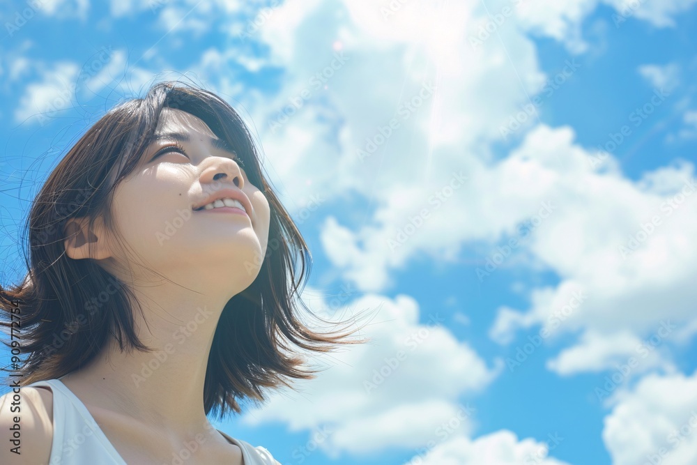 Beautiful asian woman looking at the sky with copy space for text and shine blue sky background Beautiful asian woman looking at the sky with copy space for text and shine blue sky background