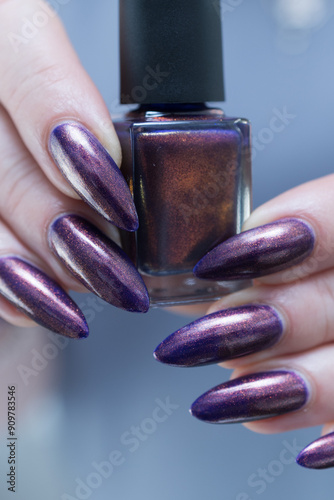 Beautiful woman's hand with long nails and multicolored nail polish, purple and brown  photo