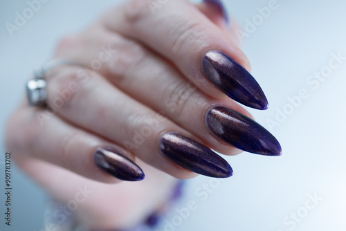 Beautiful woman's hand with long nails and multicolored nail polish, purple and brown  photo