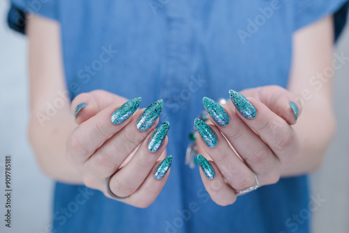 Female hand with long nails and light green and blue turquoise manicure 