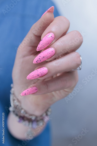 beautiful female hands with long nails and bright neon pink nail polish