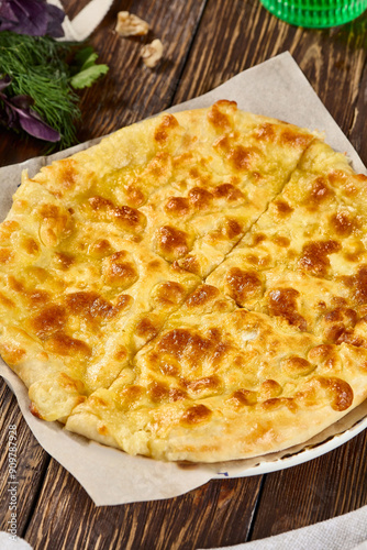 Mouthwatering Megrelian Khachapuri with Golden Cheese Crust on Rustic Wooden Table photo