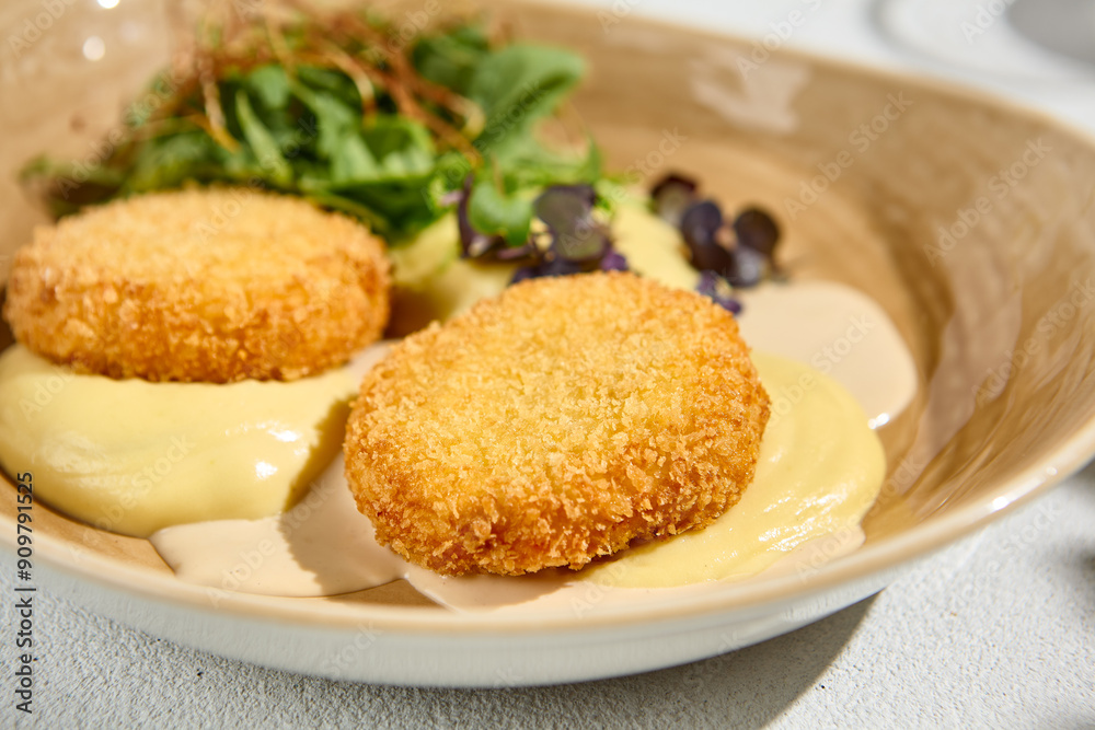 Delicious Potato Puree with Fish Cutlets and Bisque Sauce Garnished with Mixed Greens Delicious Potato Puree with Fish Cutlets and Bisque Sauce Garnished with Mixed Greens