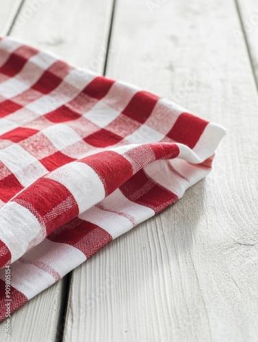 A red and white checkered table cloth laid out on a wooden table, perfect for rustic or vintage-themed events