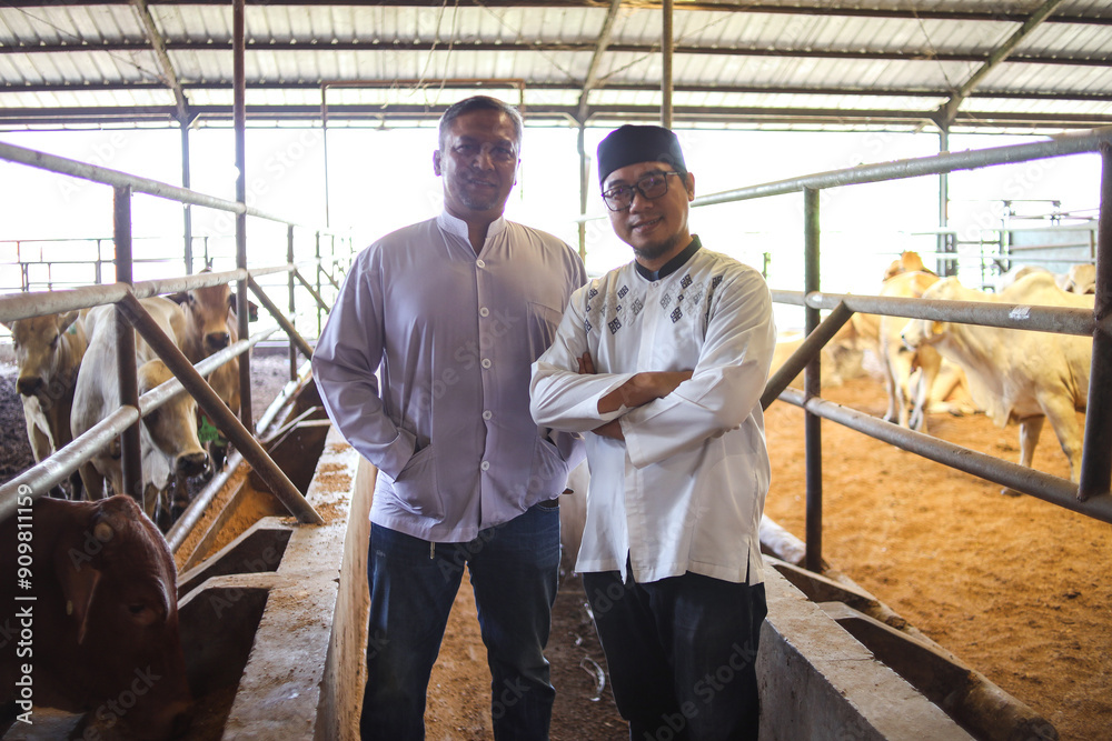 Portrait of Smiling Asian Muslim Men Looking At Camera Standing In Livestock Barn. Eid Al Adha Concept. Portrait of Smiling Asian Muslim Men Looking At Camera Standing In Livestock Barn. Eid Al Adha Concept.
