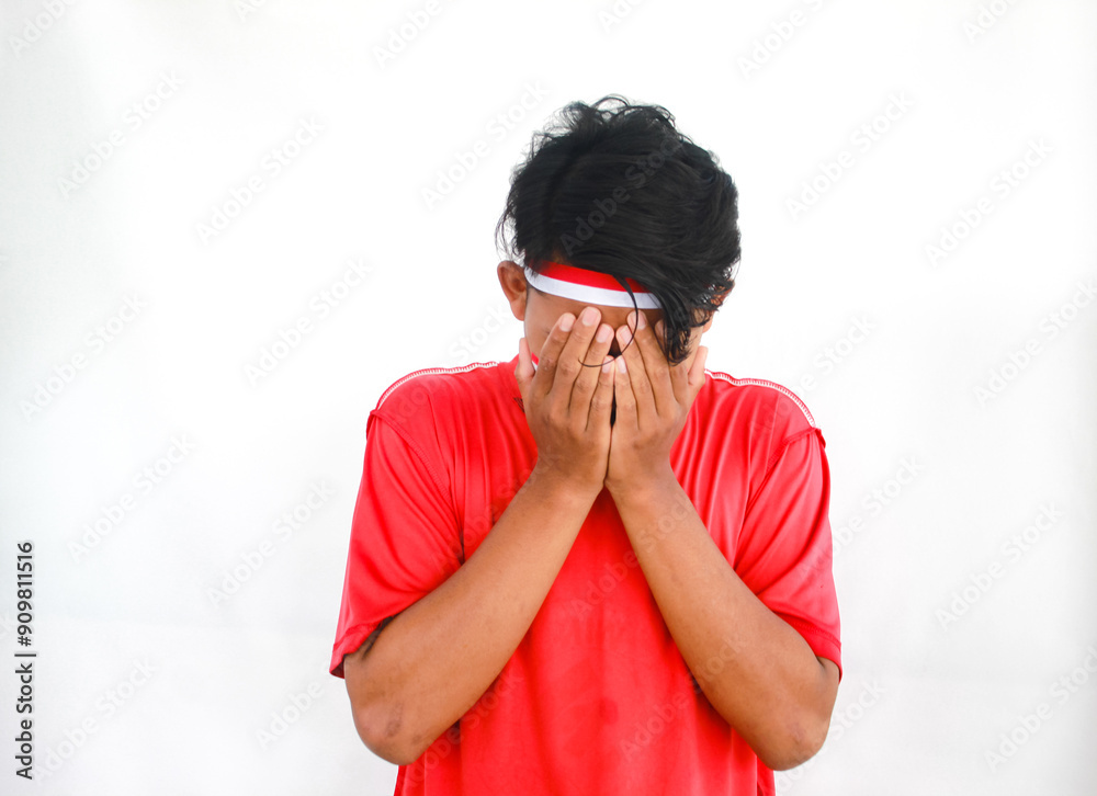 Asian Muslim man wearing independence shirt is praying and raising his head isolated on white background. Indonesian Independence day Asian Muslim man wearing independence shirt is praying and raising his head isolated on white background. Indonesian Independence day