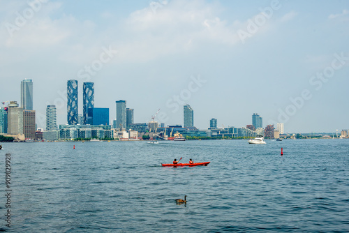 Canvas Print kayakers on a city harbor in summer with urban skyline in the background room fo