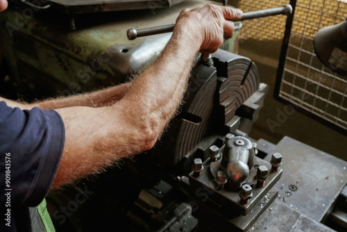 Busy man. Close-up of worker's hands operating industrial machinery in workshop