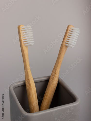 natural eco friendly toothbrush with wooden bamboo handle in a cearmic cup photo