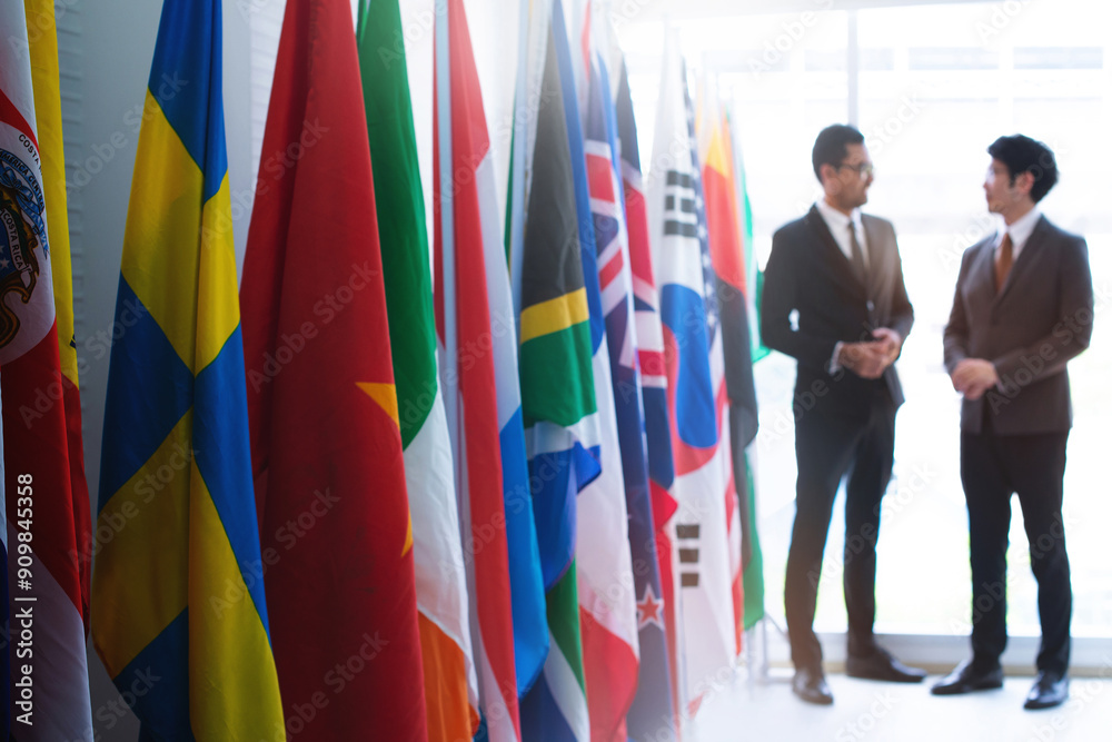 Φωτογραφία Businessmen attending an international seminar greet each other at the end of a row of flags,