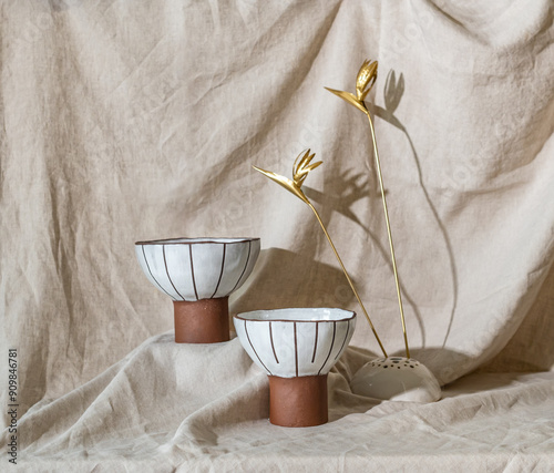 A selection of handmade stoneware ceramics in various glazes and decorations on a soft cloth background and setup photo