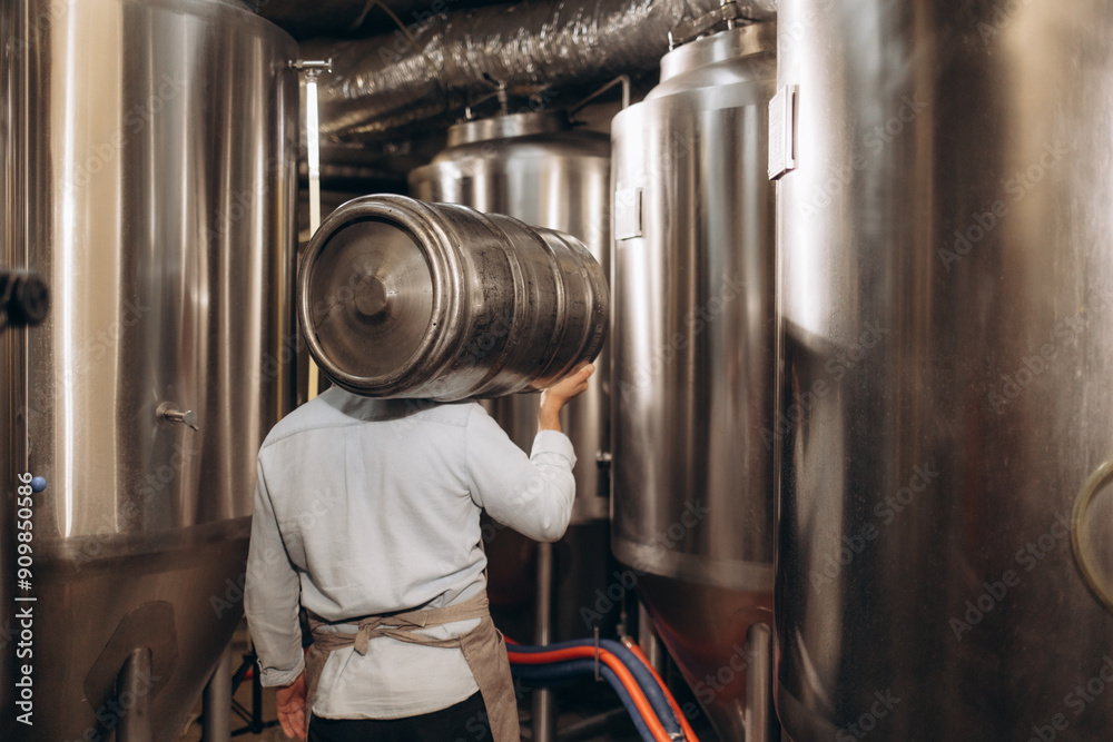 Φωτογραφία Portrait of male brewer carrying metal container at brewery factory