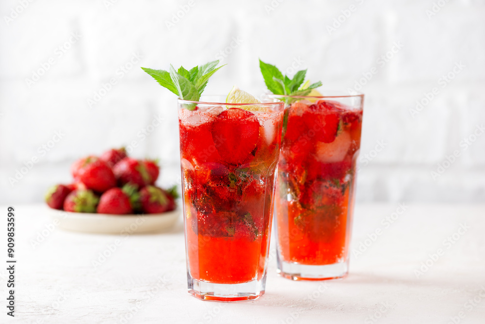 Strawberry Mojito cocktail with lime and mint on a white table. Sugar free, nonalcoholic. Strawberry Mojito cocktail with lime and mint on a white table. Sugar free, nonalcoholic.