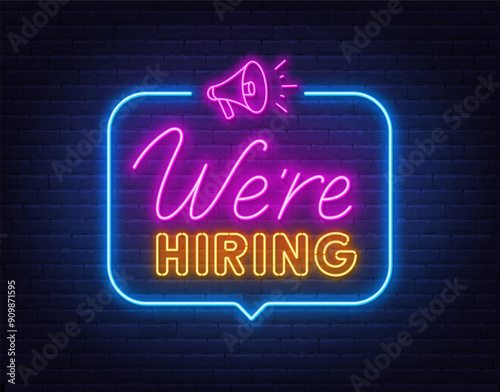 We Hiring neon sign in speech bubble on brick wall background.
