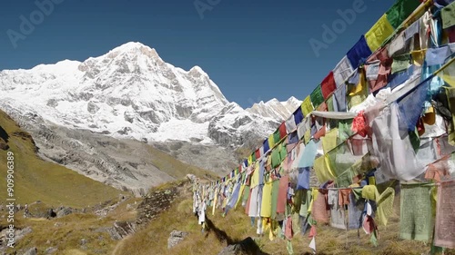 Prayer Flags in Snowcapped Mountains in Nepal, Colorful Tibetan Buddhist Prayer Flags on Blue Sky Sunny Day in the Himalayas in Annapurna, Colourful Buddhism Flags in Nature with Snowy Mountains