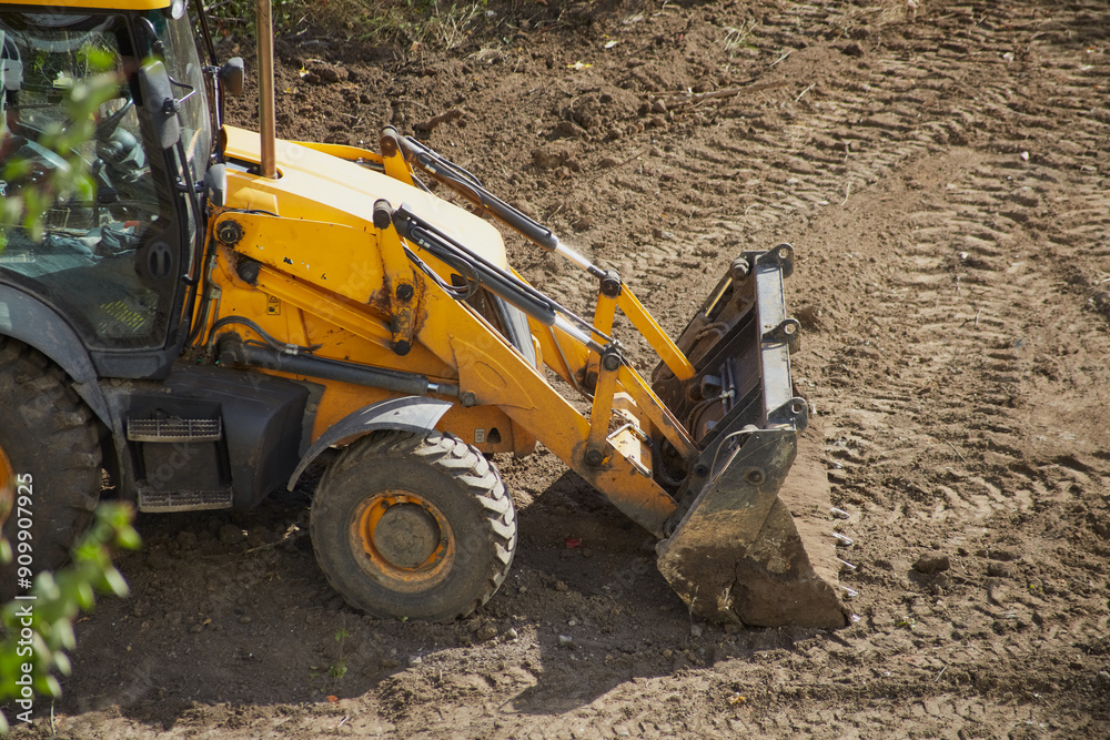 Yellow colored bulldozer with a bucket goes to work on a construction site, bulldozer work on a dirt site Yellow colored bulldozer with a bucket goes to work on a construction site, bulldozer work on a dirt site