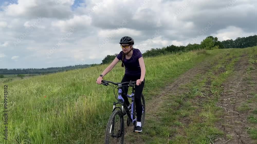 Woman cycling through a lush green countryside trail, enjoying nature and the great outdoors. Perfect for fitness, sports, and outdoor lifestyle concepts Woman cycling through a lush green countryside trail, enjoying nature and the great outdoors. Perfect for fitness, sports, and outdoor lifestyle concepts