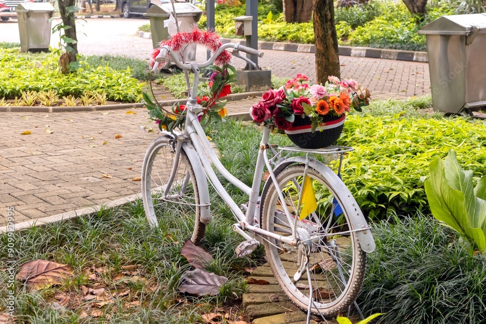 A white bicycle with a basket full of flowers on the back A white bicycle with a basket full of flowers on the back