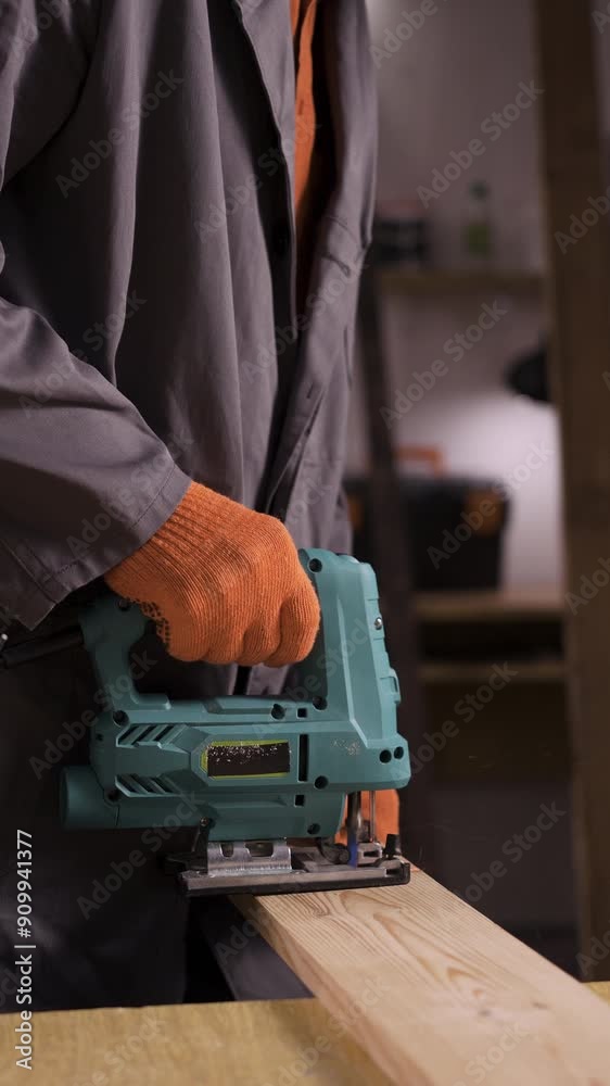 Close-up of carpenter saw the wooden board with a jig saw in a workshop. Copy space Close-up of carpenter saw the wooden board with a jig saw in a workshop. Copy space