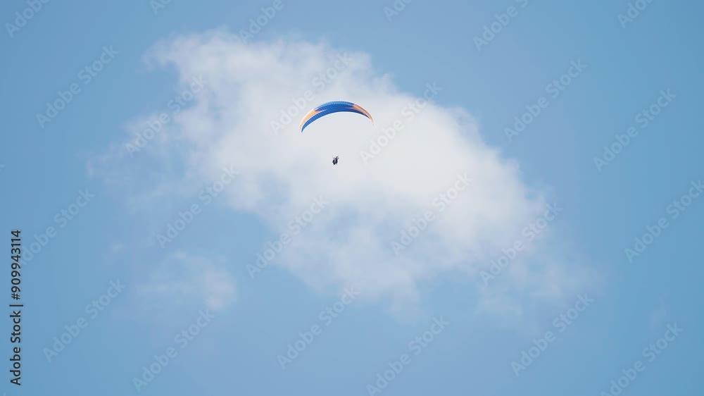 A lone paraglider soars through the skies on the parachute. Pan follow. High-quality 4k footage A lone paraglider soars through the skies on the parachute. Pan follow. High-quality 4k footage