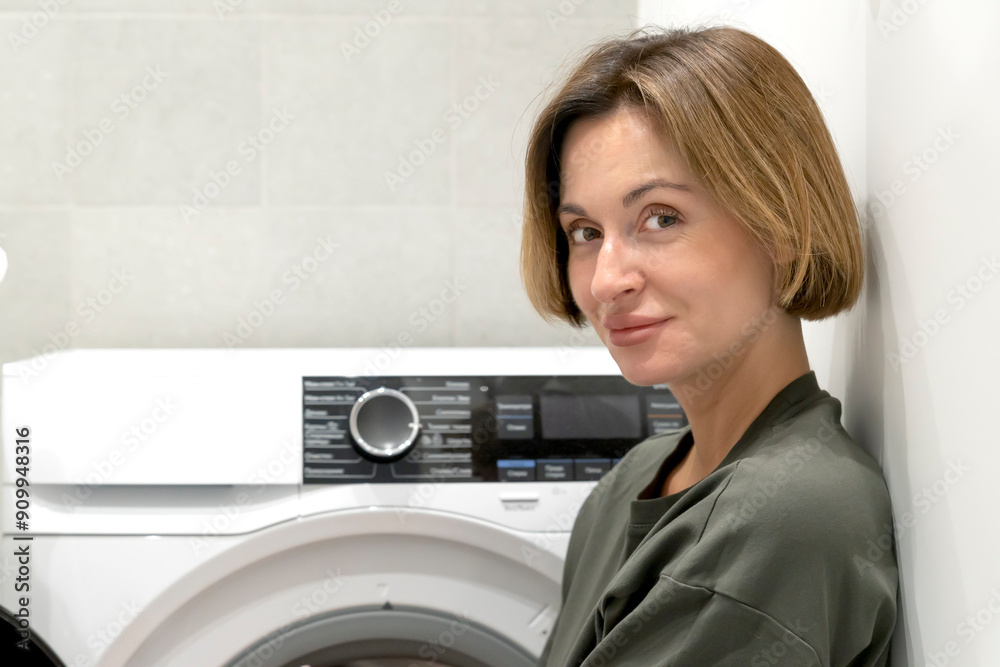 Housewife putting laundry in the washing machine Housewife putting laundry in the washing machine