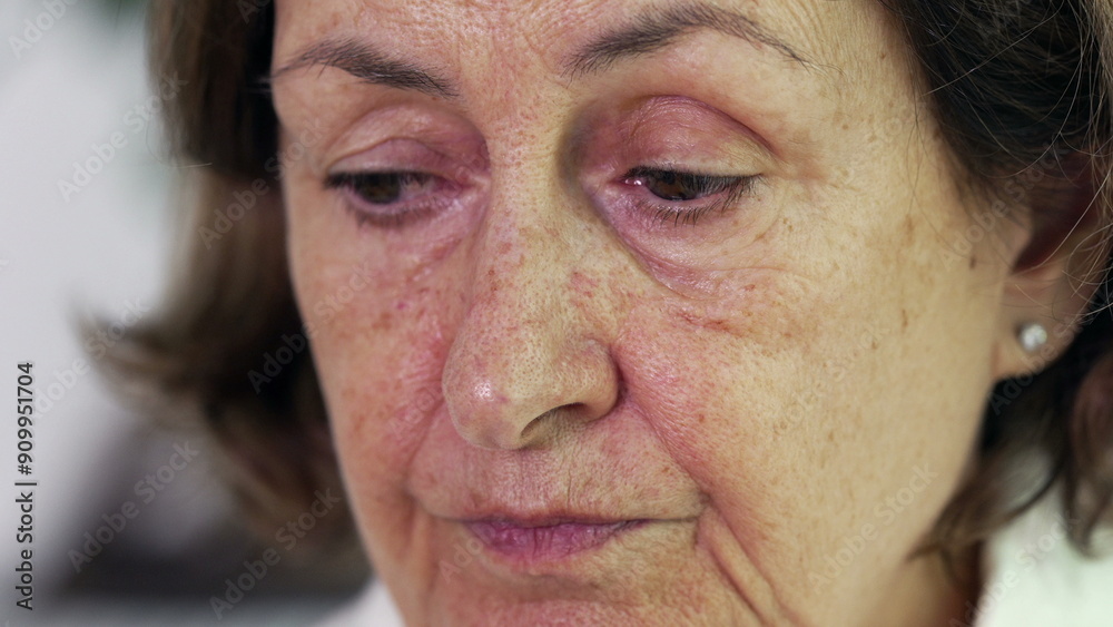 Fototapeta premium Pensive tired senior woman close-up face with concerned preoccupied expression, wrinkled 70s older person in deep mental reflection