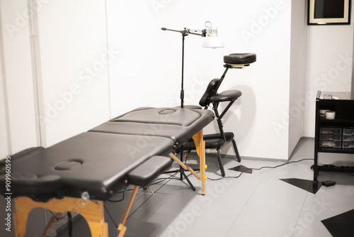 Equipped physiotherapy room with massage table, specialized treatment chair. Smart medical furniture