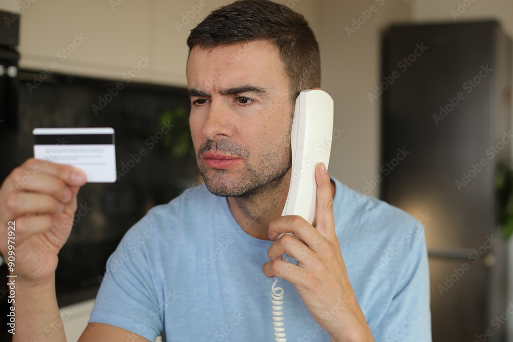 Ταπετσαρία Skeptical looking man holding credit card during phone call