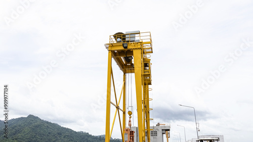 Yellow crane control watergate and water in the dam between the hills. The Khun Dan Prakan Chon Dam (this is the biggest dam in Thailand) photo