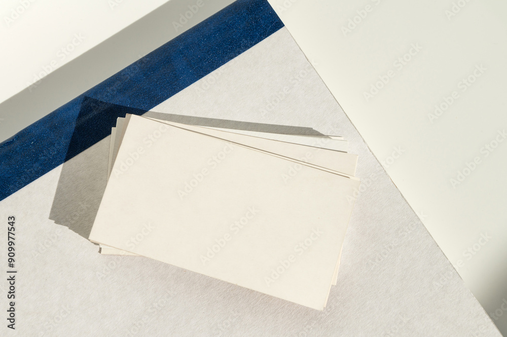 White blank business card on brown paper background with soft shadow.