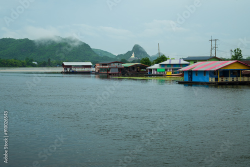 Kanchanaburi  A vibrant cluster of traditional Thai houseboats moored along the scenic Kwae Noi River near Skywalk Muang in Kanchanaburi, Thailand. Lush green mountains and forest photo