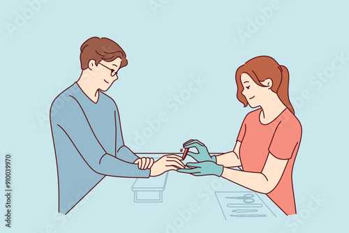 Woman does manicure for man who cares about nail hygiene and well-groomed hands, or absence of uncut cuticles. Specialist processes fingernails with file during manicure session for guy