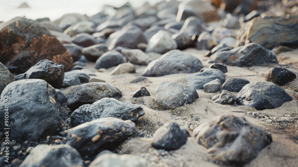 Rough, dark stones scattered across a sandy beach create a natural, rugged landscape, inviting exploration and admiration of geological formations. Rough, dark stones scattered across a sandy beach create a natural, rugged landscape, inviting exploration and admiration of geological formations.