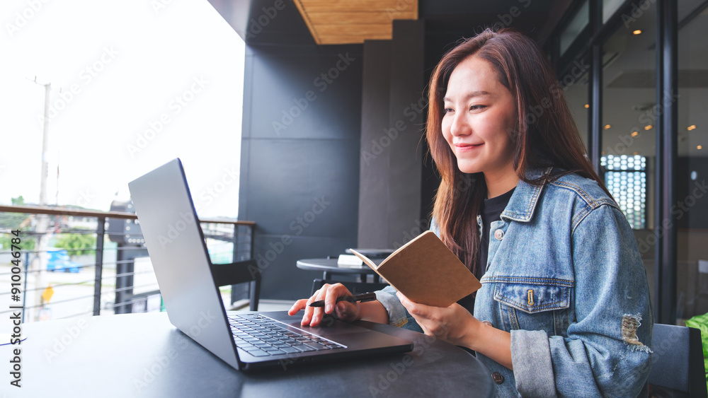 © Farknot Architect - Portrait image of a young woman writing on a notebook while working on laptop computer © Farknot Architect - Portrait image of a young woman writing on a notebook while working on laptop computer