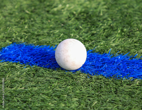 White Lacrosse Ball on Blue Line of Artificial Turf