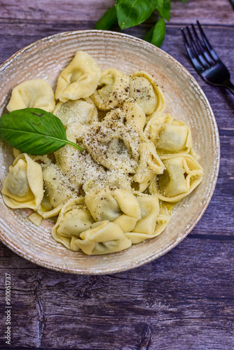 Home made vegetarian italian Tortellini with pesto genovese filled with spinach and parmesan cheese, decorated with fresh basil