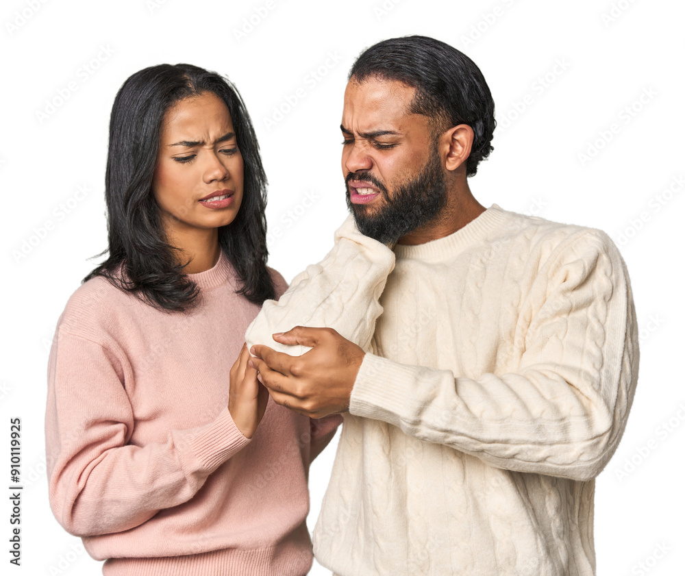 Fototapeta premium Young Latino couple in studio massaging elbow, suffering after a bad movement.