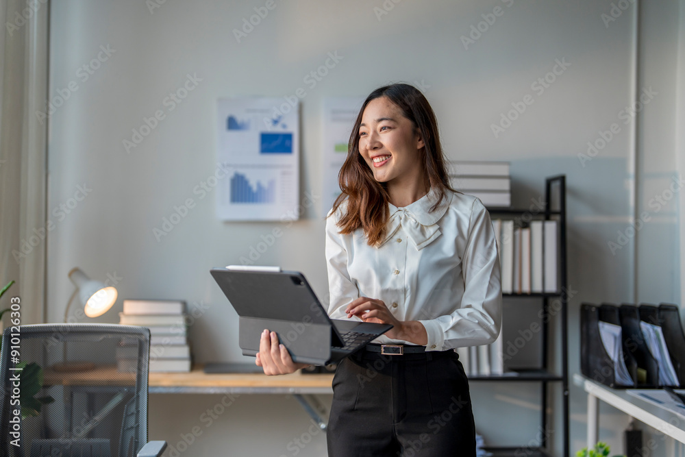 Smiling asian businesswoman working on digital tablet in modern office Smiling asian businesswoman working on digital tablet in modern office