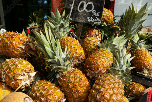 Stack of pineapple, weekly market at Rotterdam. Sweet fruit, raw, food, tasty, market stall, trading. photo