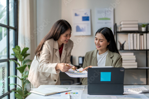 Two businesswomen analyzing financial charts and discussing business strategy