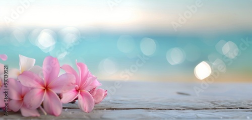 Pink Flowers on a Wooden Surface With Ocean in Background at Sunrise