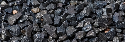 Wallpaper Mural Various sizes of black crushed stone aggregate form a textured surface, commonly used in construction and landscaping projects under bright sunlight Torontodigital.ca