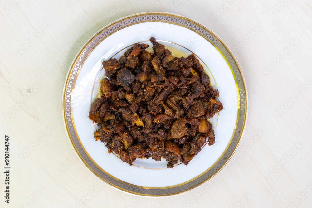 Delicious Bangladeshi food gorur bot bhaja or gorur vuri bhuna in a white plate on wooden background. Beef Bhuri Vaja is a popular Bengali dish made from beef tripe. Delicious Bangladeshi food gorur bot bhaja or gorur vuri bhuna in a white plate on wooden background. Beef Bhuri Vaja is a popular Bengali dish made from beef tripe.