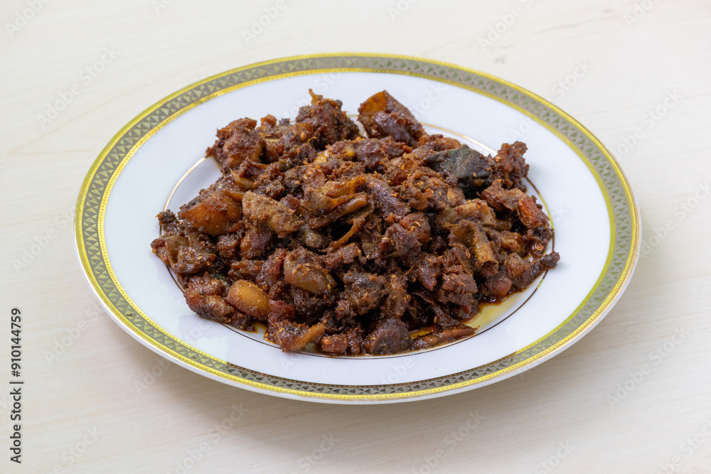 Gorur bot bhaja or gorur vuri bhuna in a white plate on wooden background. Beef Bhuri Vaja is a popular Bengali (Bangladeshi) dish made from beef tripe. Gorur bot bhaja or gorur vuri bhuna in a white plate on wooden background. Beef Bhuri Vaja is a popular Bengali (Bangladeshi) dish made from beef tripe.