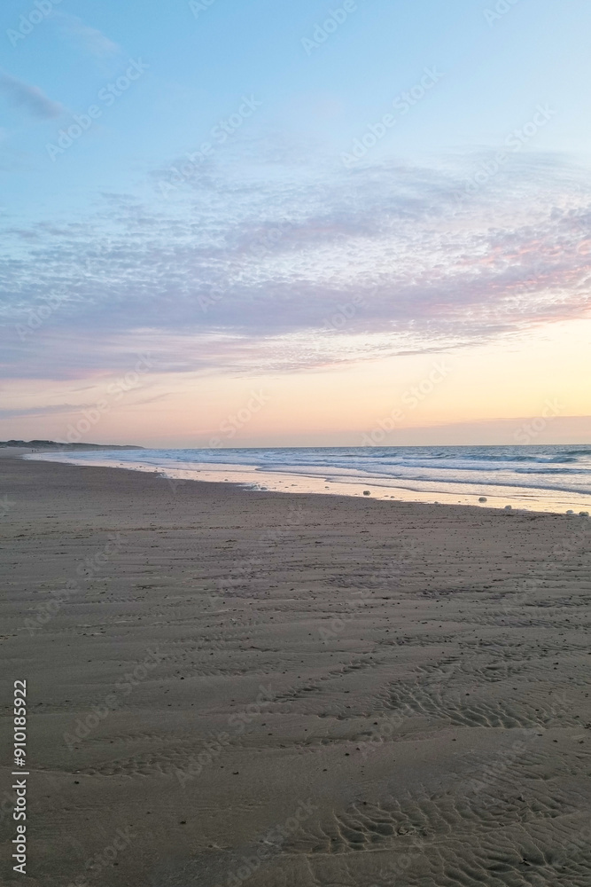 Obraz premium Serene Early Morning Beach Sunrise with Soft Ocean Waves and Pastel Sky