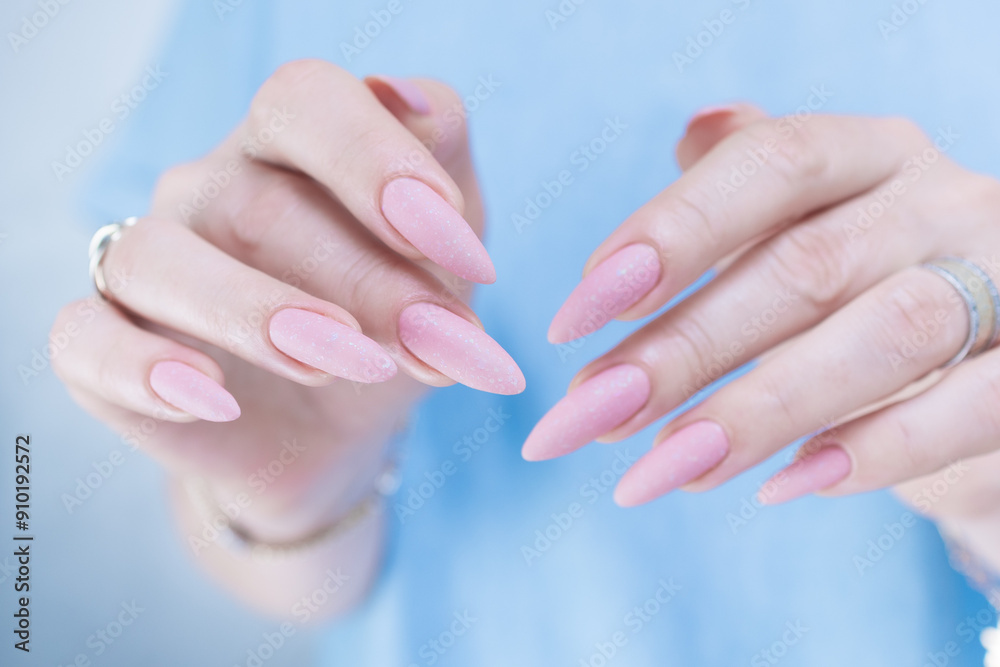 Woman's hands with long nails and a light pink color nail polish Woman's hands with long nails and a light pink color nail polish